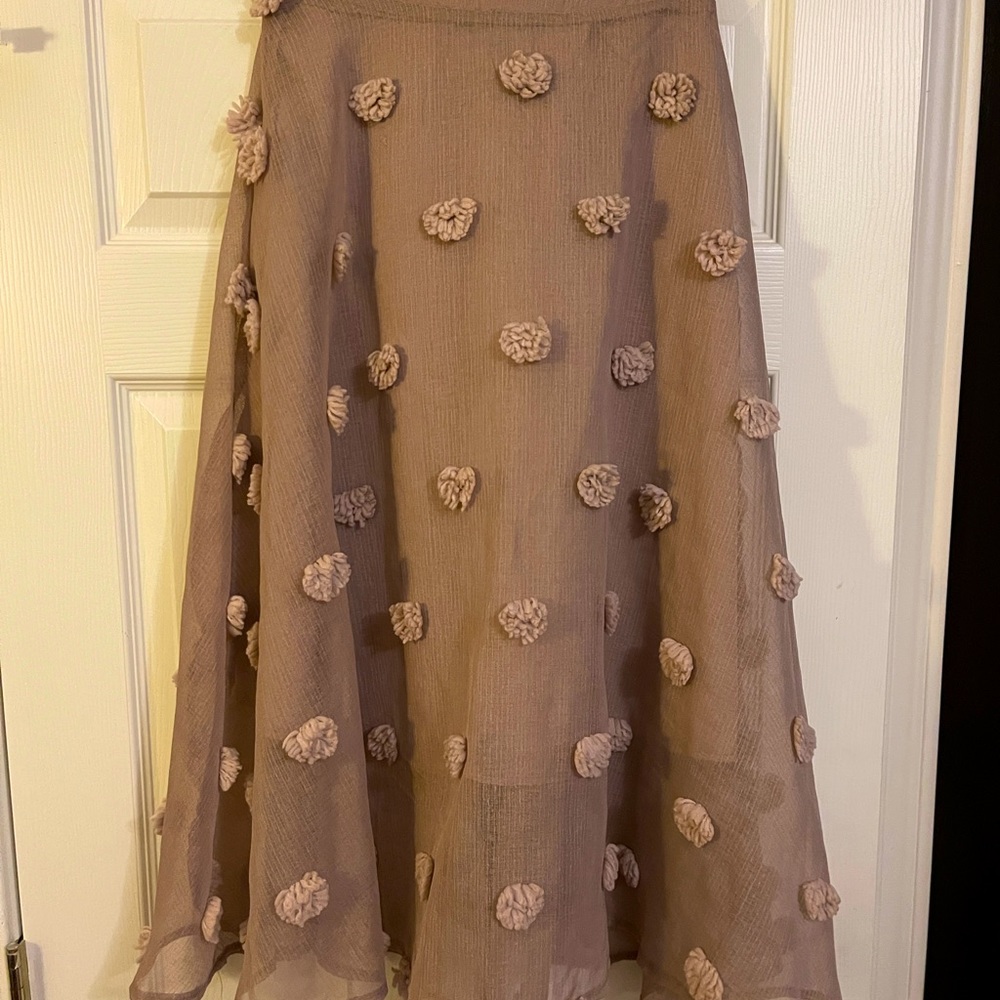 Chic skirt with pom pom accents that screams brunch and bubbly!